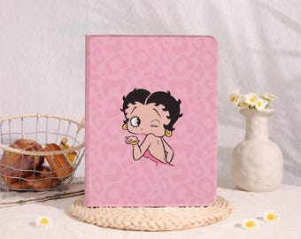 May include: A rectangular pink tablet case featuring a repeating light pink leopard print pattern and a central graphic of the cartoon character Betty Boop blowing a kiss. The character has black hair, gold hoop earrings, and a pink dress.