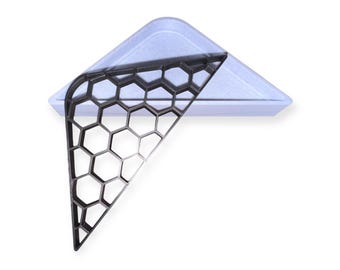 May include: A black honeycomb-shaped mold for baking, resting on a light blue triangular baking pan.