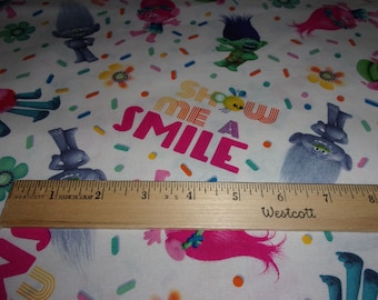 Trolls Poppy Show me a Smile Toss White Background Fabric Sold by Yard