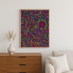 May include: A framed art print with a vibrant, abstract design. The artwork features a swirling pattern of colorful lines and shapes in shades of pink, purple, blue, yellow, and green. The frame is a light wood color, and the print is displayed on a white wall.