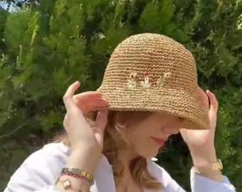 Cappello da pescatore all'uncinetto con ricami floreali in rafia: cappello estivo fatto a mano