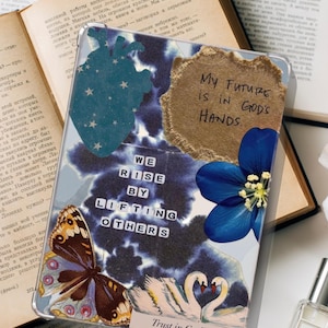Puede incluir: Funda de teléfono transparente con un diseño de collage. Presenta un corazón azul, una mariposa, una flor y cisnes. El texto incluye "My Future is in God's Hands" y "We Rise by Lifting Others."