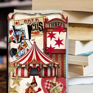 Op de afbeelding: Decoratieve telefoonhoes met een vintage circusthema. Het ontwerp omvat een rood-wit gestreepte circustent, speelkaarten en de woorden "SOLO CIRCUS" en "TICKETS". De hoes heeft ook afbeeldingen van clowns en sterren.