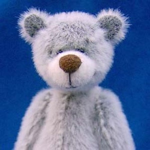 May include: A gray plush teddy bear with a brown nose and blue eyes. The bear is looking directly at the camera.