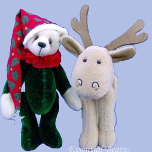 Pode incluir: Um urso de pelúcia verde vestindo um chapéu de Papai Noel vermelho e verde e uma rena de pelúcia marrom com chifres.
