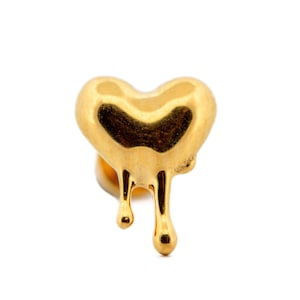 May include: A gold-colored heart-shaped earring with a dripping design. The earring has a smooth, polished surface and a post backing. The dripping effect adds a unique and stylish touch to the jewelry.