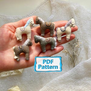 May include: Five miniature fabric horse figurines in shades of brown and cream, with embroidered details. Each horse has a saddle and mane. The image includes a sign that says "PDF Pattern".