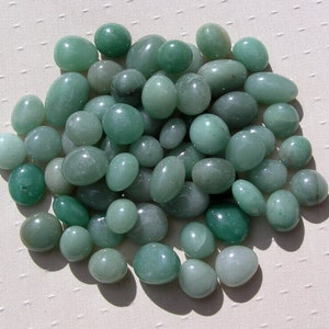 Puede incluir: Un gran grupo de piedras lisas y verdes. Las piedras son de forma ovalada y tienen un color verde claro.
