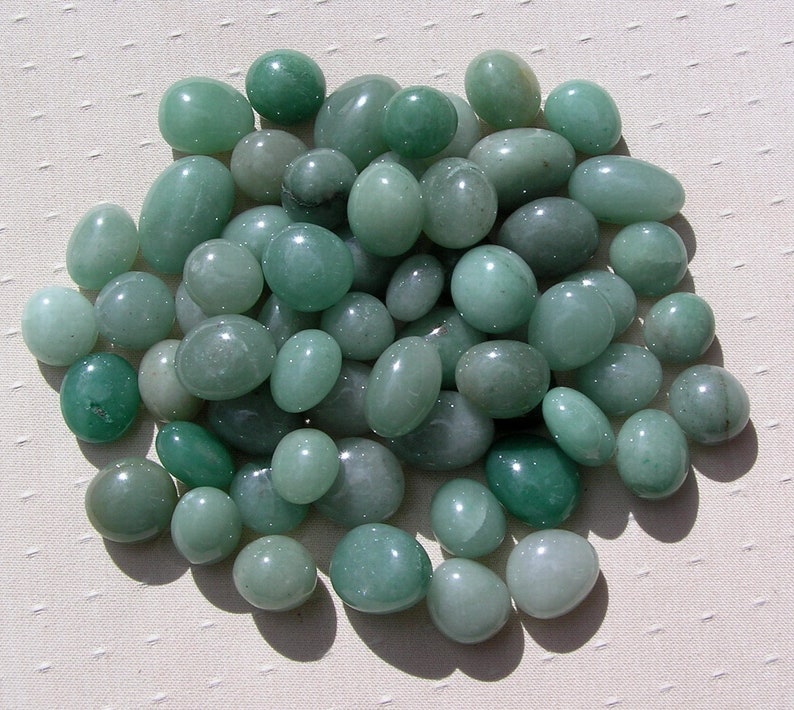 Puede incluir: Un gran grupo de piedras lisas y verdes. Las piedras son de forma ovalada y tienen un color verde claro.