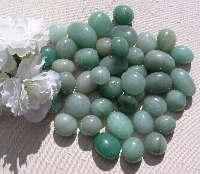 Puede incluir: Una colecci&oacute;n de piedras lisas y verdes, de varios tama&ntilde;os y formas, con un acabado pulido y brillante.