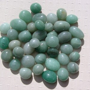 Puede incluir: Una colecci&oacute;n de piedras lisas y verdes, de diferentes tama&ntilde;os y formas. Las piedras son de color verde claro.