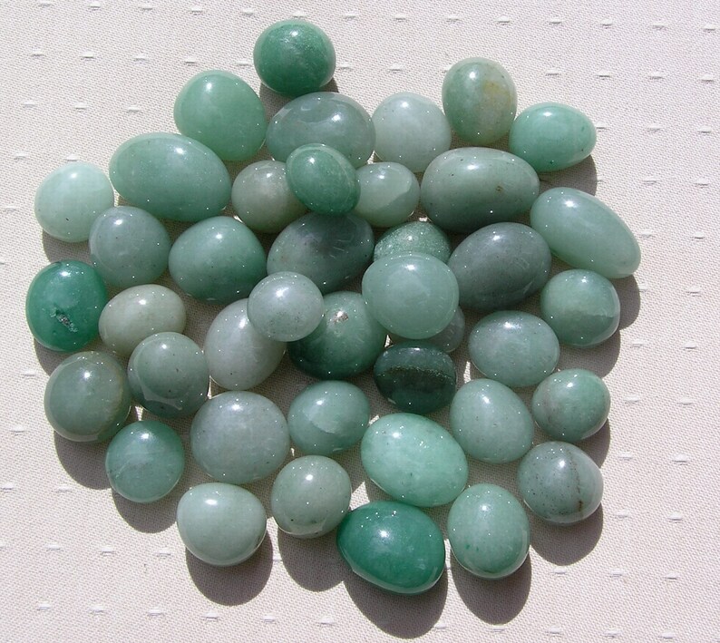 Puede incluir: Una colecci&oacute;n de piedras lisas y verdes, de diferentes tama&ntilde;os y formas. Las piedras son de color verde claro.