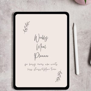 Könnte beinhalten: Ein digitales Tablet mit einem "Wochen-Essensplaner" auf cremefarbenem Hintergrund. Der Text ist handschriftlich, mit Blattillustrationen. Ein weißer Stift liegt neben dem Tablet auf einer grauen Oberfläche. Der Planer ist für vielbeschäftigte Menschen.