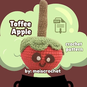 May include: A crocheted toffee apple with a red body, green leaf-like top, and a brown stem. The apple has a smiling face with brown eyes. Text on the image reads "Toffee Apple", "crochet pattern", and "by: meiscrochet". A PDF icon is also present.