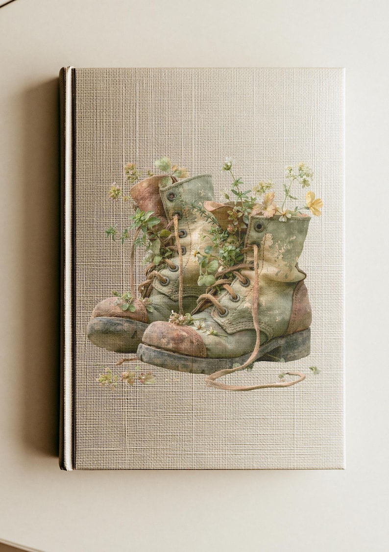 May include: A hardcover book with a textured beige cover featuring a central illustration of a pair of weathered, sage green lace-up boots. Small yellow and white wildflowers and green foliage grow out from the interior of the boots.