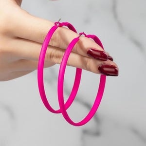 May include: A white ceramic mug with a black handle and the text "But first, coffee" in a black, handwritten-style font. The mug is on a white surface.