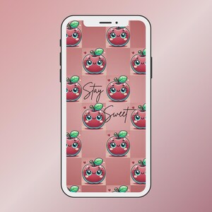 Könnte beinhalten: Ein rosa und weißes Smartphone mit einem roten Apfelmuster und dem Text "Stay Sweet" auf dem Bildschirm.