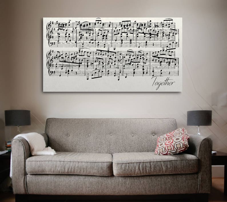 May include: A black and white sheet music print with the word "Together" at the bottom. The print is framed and hanging on a wall above a gray couch.
