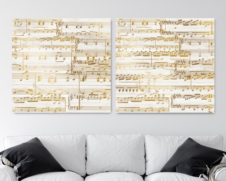 May include: Two white wood panels with gold musical notes printed on them. The panels are hung on a white wall above a white couch.