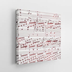 May include: A canvas print featuring musical notation in a deep red hue against a white background. The sheet music is densely packed with notes, rests, and clef symbols, creating a visually rich and artistic composition. The canvas is mounted on a wooden frame.