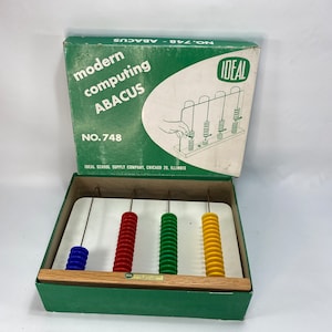 May include: Vintage Ideal No. 748 Modern Computing Abacus in a green box with a white interior. The abacus has four rows of colourful beads, red, blue, green, and yellow.