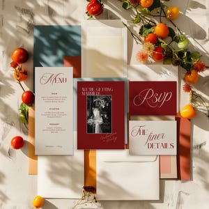 Könnte beinhalten: Hochzeitspapeterie-Set mit Menü, RSVP-Karte und Einladung mit dem Text "We're Getting Married!" und "The finer details". Das Set ist in Burgunderrot und Weiß gehalten, mit einem Foto eines Paares. Frische Tomaten und Blumen umgeben die Papeterie.