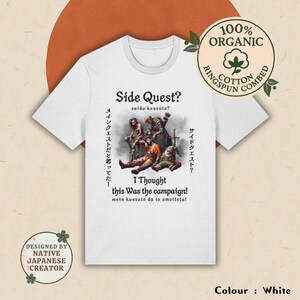 Könnte beinhalten: Weißes T-Shirt mit einem Grafikdruck einer Gruppe von Fantasy-Charakteren in einer Waldlandschaft. Der Text "Side Quest?" steht über dem Grafikdruck, und der Text "I Thought this Was the campaign!" steht unter dem Grafikdruck. Der Text "saido kussuto?" steht in kleinerer Schrift unter "Side Quest?" und der Text "mein kuesuto da to omotteta!" steht in kleinerer Schrift unter "I Thought this Was the campaign!"