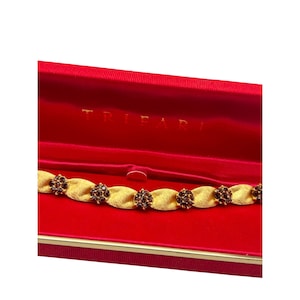 Pulsera TRIFARI en caja original Trifari en tono dorado cepillado y pedrería de topacio ahumado marrón.