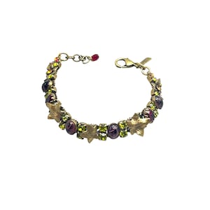May include: A gold-tone bracelet with a chain link design. The bracelet is adorned with green and purple gemstones and gold leaf accents.