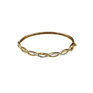 May include: A gold bangle bracelet with a twisted design and small clear stones set into the metal.