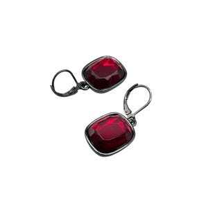 May include: A pair of leverback earrings featuring large, square-cut, ruby-red gemstones set in dark metal. The earrings have a simple, elegant design, with a lever closure for secure wear.