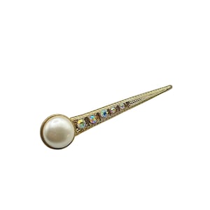 May include: A gold-tone brooch with a single white pearl and iridescent rhinestones.