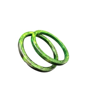 May include: Two green and yellow bangles with a marbled pattern.