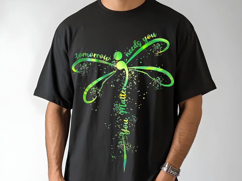 May include: Black t-shirt with a green and yellow dragonfly graphic and the text "tomorrow needs you you matter".