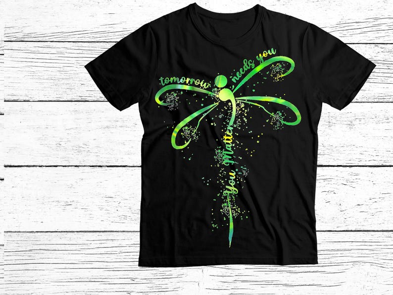 May include: Black t-shirt with a green and yellow dragonfly design. The dragonfly has a semicolon in its body and the text "tomorrow needs you you matter" is written vertically along its body.