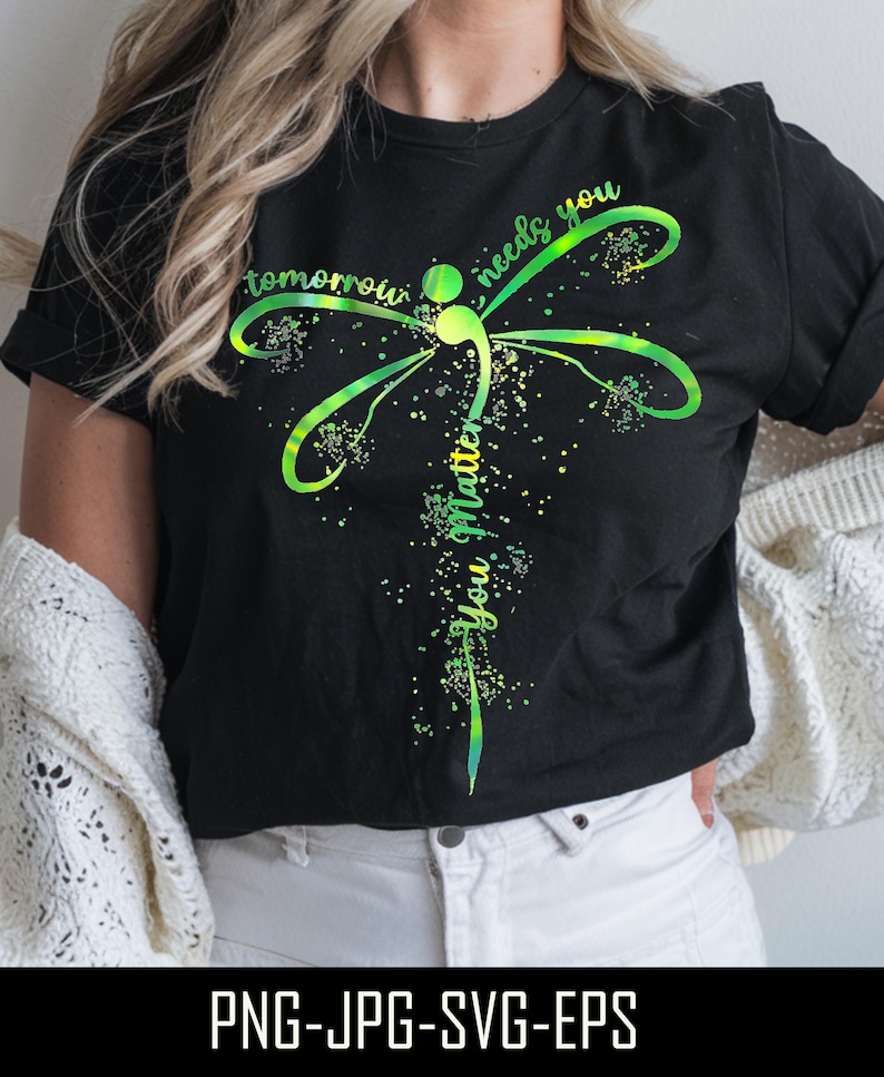 May include: Black t-shirt with a green and yellow dragonfly design. The dragonfly has a semicolon in its body and the text "tomorrow needs you you matter" is written around it.