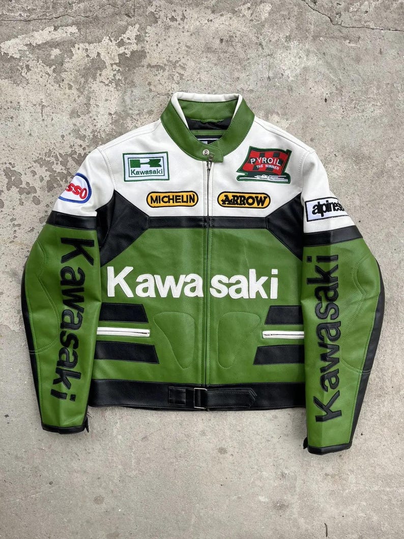 K&ouml;nnte beinhalten: Eine gr&uuml;ne, wei&szlig;e und schwarze Kawasaki Motorrad-Rennjacke. Die Jacke hat das Kawasaki-Logo in gro&szlig;en wei&szlig;en Buchstaben auf der Brust und an den &Auml;rmeln. Aufn&auml;her sind Michelin, Arrow und Pyroil.