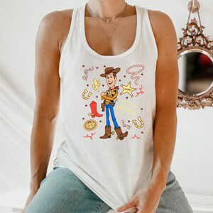 A person wearing a white tank top with a cartoon character from the Toy Story franchise.