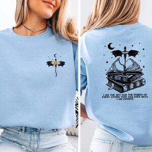 The image is a collage of two photos of a woman wearing a light blue t-shirt with a dragon design and a quote on the back.