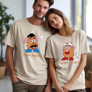 A man and a woman wearing matching t-shirts with cartoon characters on them.