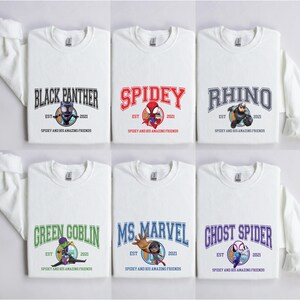 Puede incluir: Seis camisas blancas de manga larga con diferentes dise&ntilde;os de personajes de Marvel. Cada camisa presenta un gr&aacute;fico colorido de un personaje, el nombre del personaje y el texto "Spidey and his amazing friends".