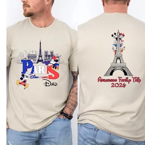 a man wearing a beige t-shirt with a graphic design featuring the Eiffel Tower and Mickey Mouse. The design includes the text "PARIS" and "Disneyland" along with the text "DAD" and "Andrea's Family Trip" printed on the back of the shirt.