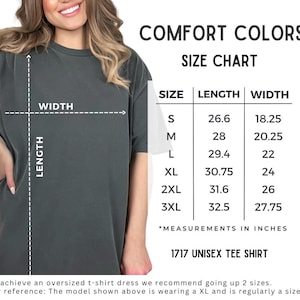 Może przedstawiać: Ciemnoszara koszulka unisex z tabelą rozmiar&oacute;w. Tabela zawiera wymiary w calach dla rozmiar&oacute;w od S do 3XL. Widoczny jest r&oacute;wnież tekst "COMFORT COLORS" i "1717 UNISEX TEE SHIRT".