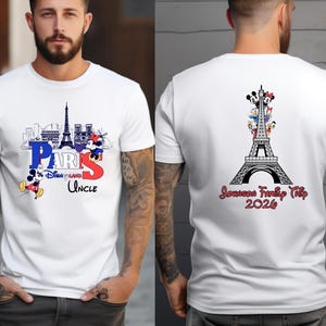A man wearing a white t-shirt with a graphic design featuring the Eiffel Tower and Mickey Mouse.
