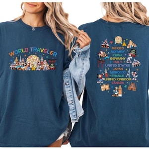 two women wearing blue t-shirts with colorful graphics and text on the back.