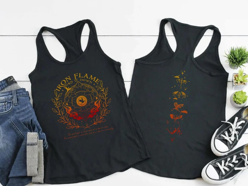 two black tank tops with different designs, laid out on a white background. There are also some jeans, a pair of sneakers, and a potted plant in the scene.