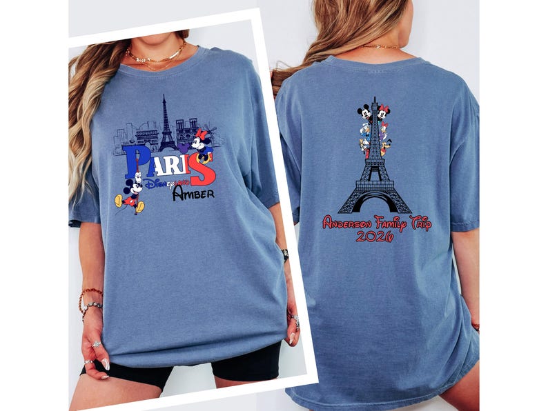 A woman wearing a blue t-shirt with a graphic of Paris and Mickey Mouse, along with the text "Paris" and "Amber". The t-shirt also features a graphic of the Eiffel Tower and the text "Anderson Family Trip 2016".