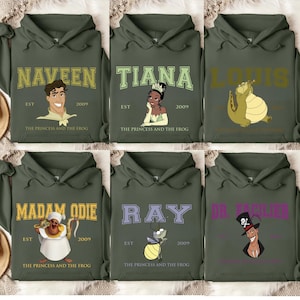 May include: Six green hooded sweatshirts with different characters from the Disney movie The Princess and the Frog. Each sweatshirt has the character's name in a collegiate font with the words "The Princess and the Frog" and "Est. 2009" below.