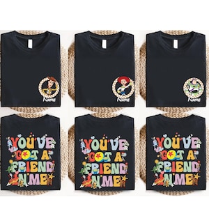a collection of six black t-shirts with colorful text and characters, arranged in a grid-like pattern.