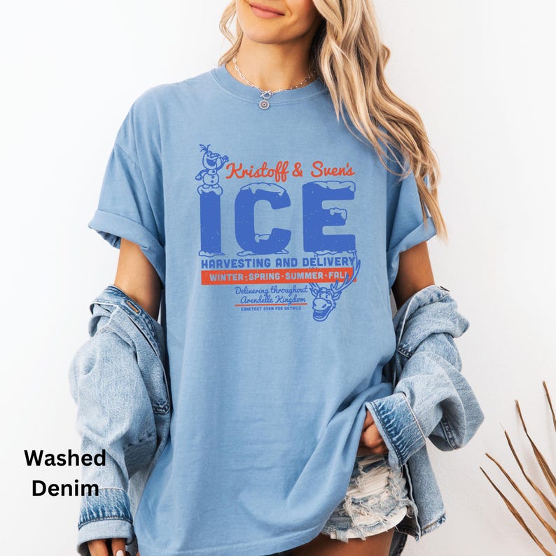 以下が含まれることがあります： クリストフとスヴェンのアイスハーベスティング＆デリバリーのグラフィックがプリントされた薄いブルーのTシャツ。グラフィックには、青と白のアイスロゴと、青と白で「Kristoff & Sven's ICE」というテキストが描かれています。「HARVESTING AND DELIVERY」というテキストは赤と白で書かれています。「WINTER-SPRING-SUMMER-FALL」というテキストは赤と白で書かれています。「Delivering throughout Arendelle Kingdom」というテキストは赤と白で書かれています。グラフィックには、クリストフとスヴェンのカートゥーン画像も含まれています。